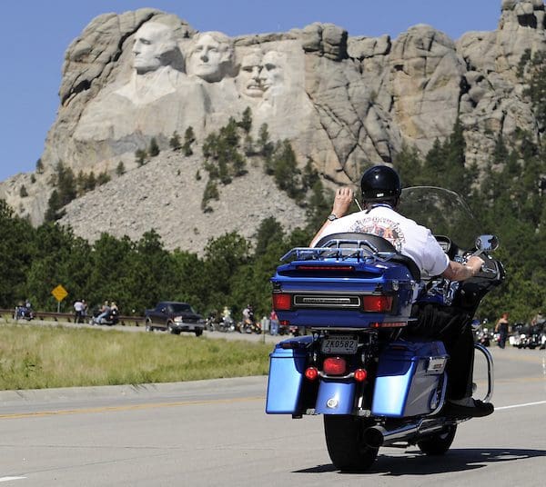 Person on motorcycle in front of Mt. Rushmore